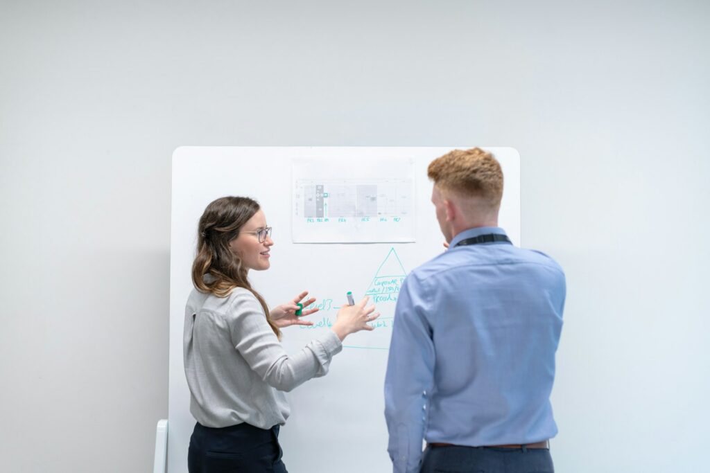 Zwei Kollegen diskutieren am Whiteboard