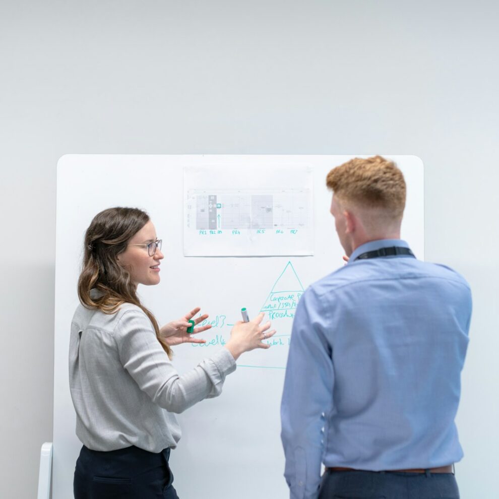 YourInsight companion Zwei Kollegen diskutieren am Whiteboard