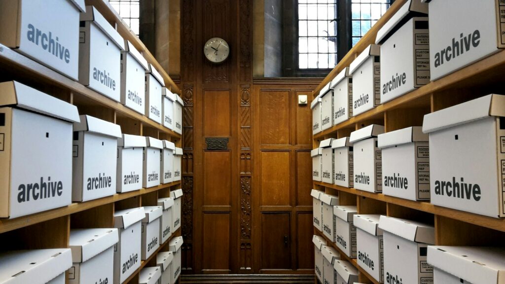 Weiße Archivboxen in Holzregalen