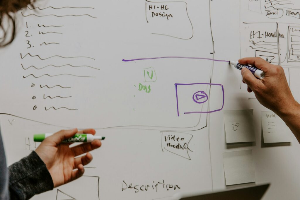 Zwei Personen skizzieren am Whiteboard